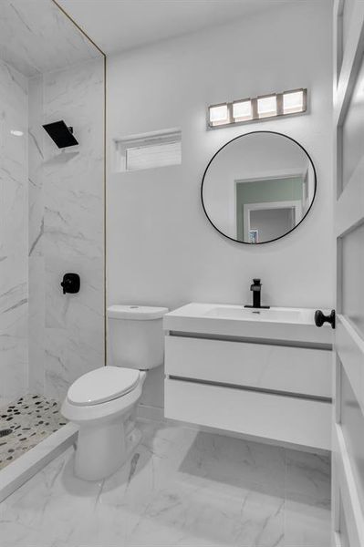Full bath featuring vanity, a marble finish shower, and light marble finish flooring Full bath featuring vanity, a marble finish shower, and light marble finish flooring