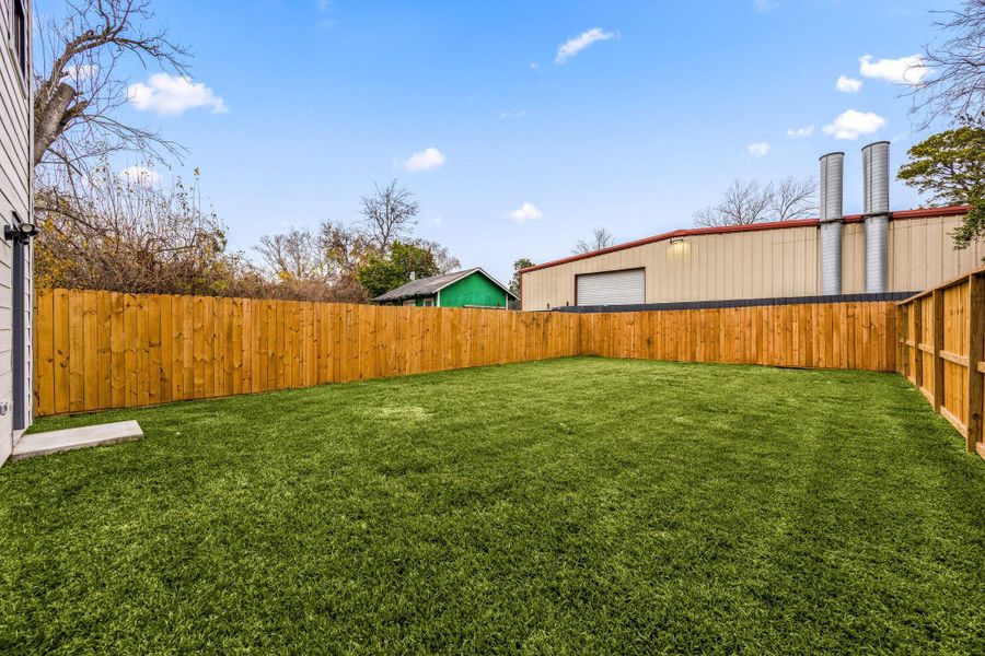 Spacious private backyard featuring a fully fenced yard, lush grass, and open green space ideal for outdoor entertaining, gardening, pets, or play. A great extension of the home offering privacy and flexibility for outdoor living.
