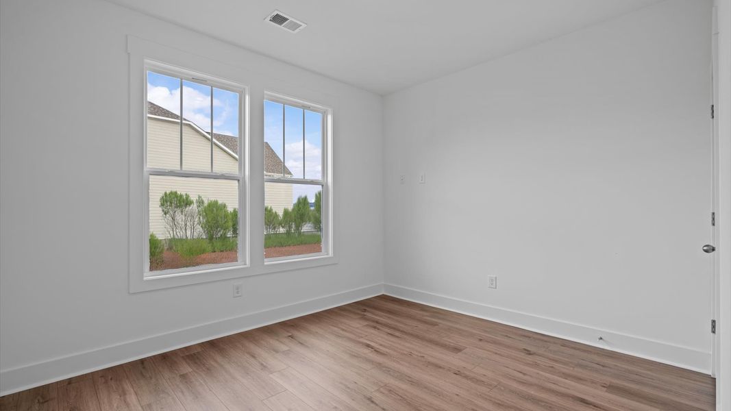 Functional secondary bedrooms with hardwood flooring and modern touches in an exceptional layout