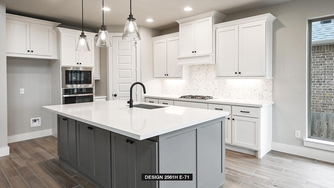 Kitchen with sink, hanging light fixtures, a center island with sink, stainless steel appliances, and white cabinets