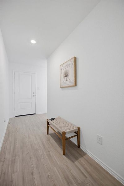 Crisp white walls and clean lines define this inviting entryway featuring light-toned  vinyl flooring.