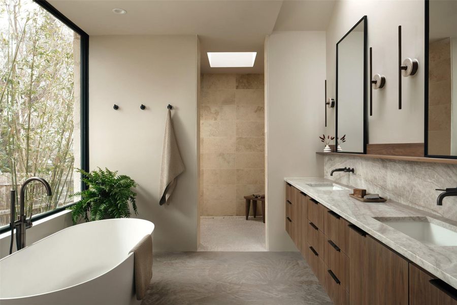 Primary bathroom with double vanity, a skylight, Taj Mahal leathered Quartzite countertops, generous travertine walk-in shower with skylight, soaking tub, under cabinet lighting.