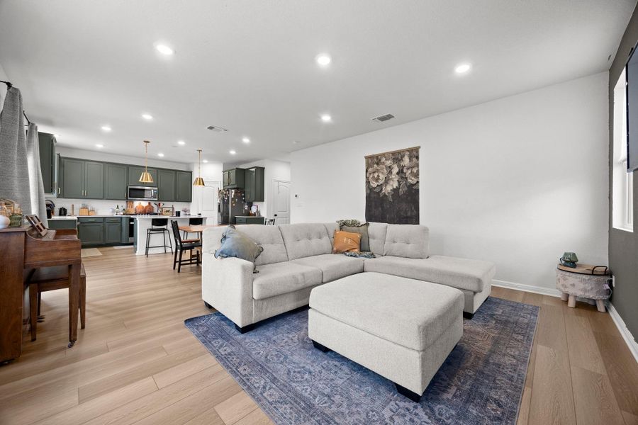 Expansive open-concept living space with light wood-finish flooring