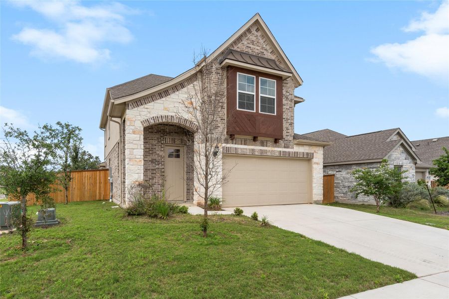 View of front of house with a garage, driveway, brick siding, and stone siding View of front of house with a garage, driveway, brick siding, and stone siding