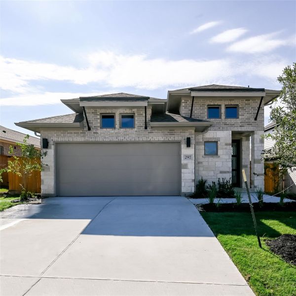 Prairie-style house with driveway, brick siding, a shingled roof, stone siding, and a front yard
