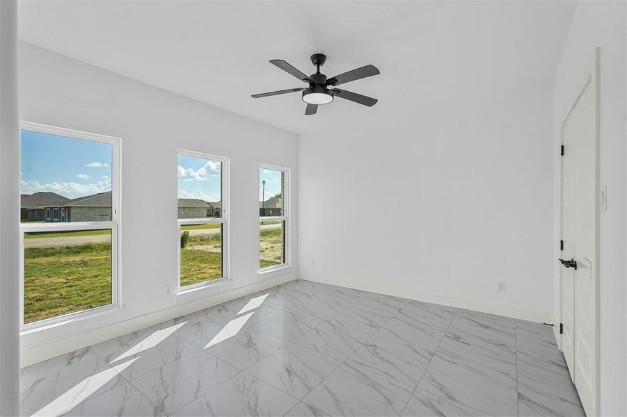 Spare room with ceiling fan and a wealth of natural light