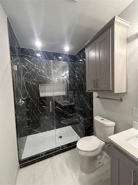 Full bath with vanity, a marble finish shower, and recessed lighting Full bath with vanity, a marble finish shower, and recessed lighting