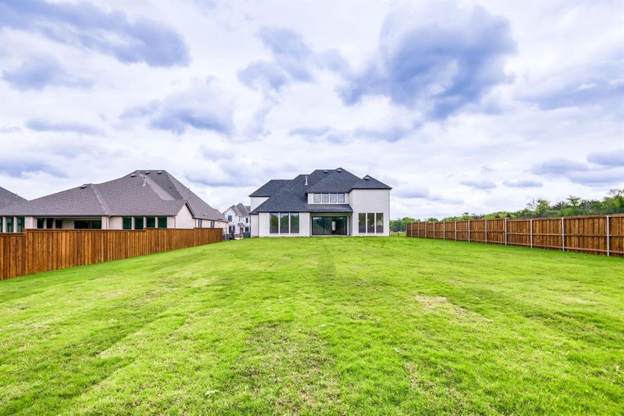 Back of house with a fenced backyard and a patio area