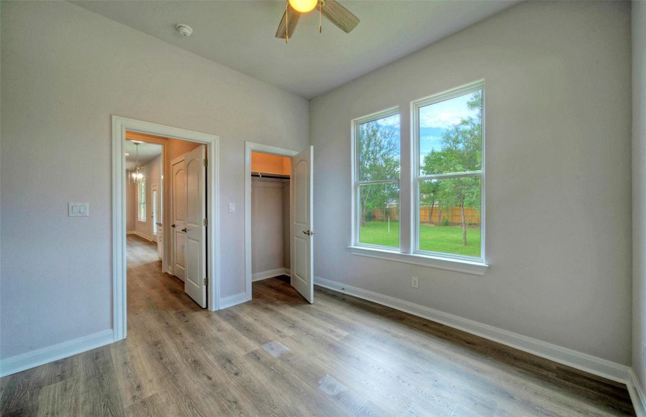 Unfurnished bedroom featuring wood finished floors, ceiling fan, and a closet Unfurnished bedroom featuring wood finished floors, ceiling fan, and a closet
