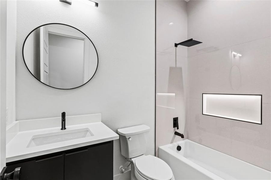 Full bathroom featuring tiled shower / bath, vanity, and toilet