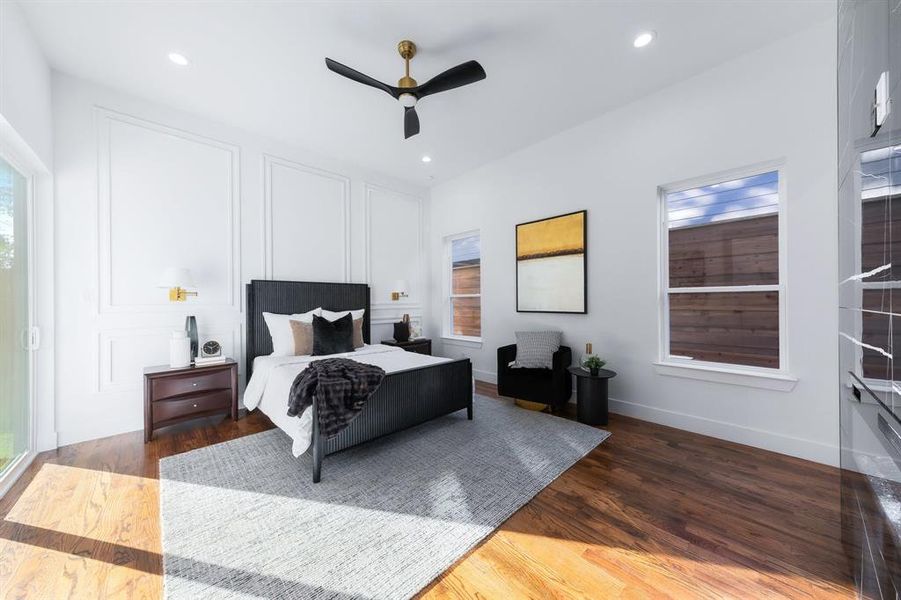 Master bedroom featuring wainscoting with wall mounted lighting, wood finished floors, and recessed lighting. Master bedroom featuring wainscoting with wall mounted lighting, wood finished floors, and recessed lighting.