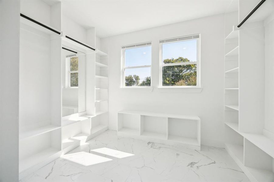 Spacious closet with light marble finish floors