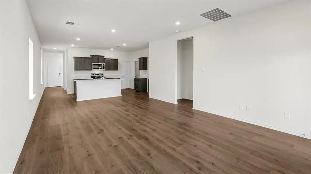 Open concept living area with hardwood style flooring and recessed lighting