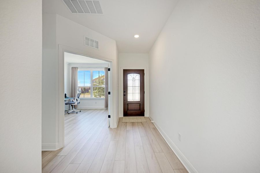 Foyer with light wood-style floors and recessed lighting