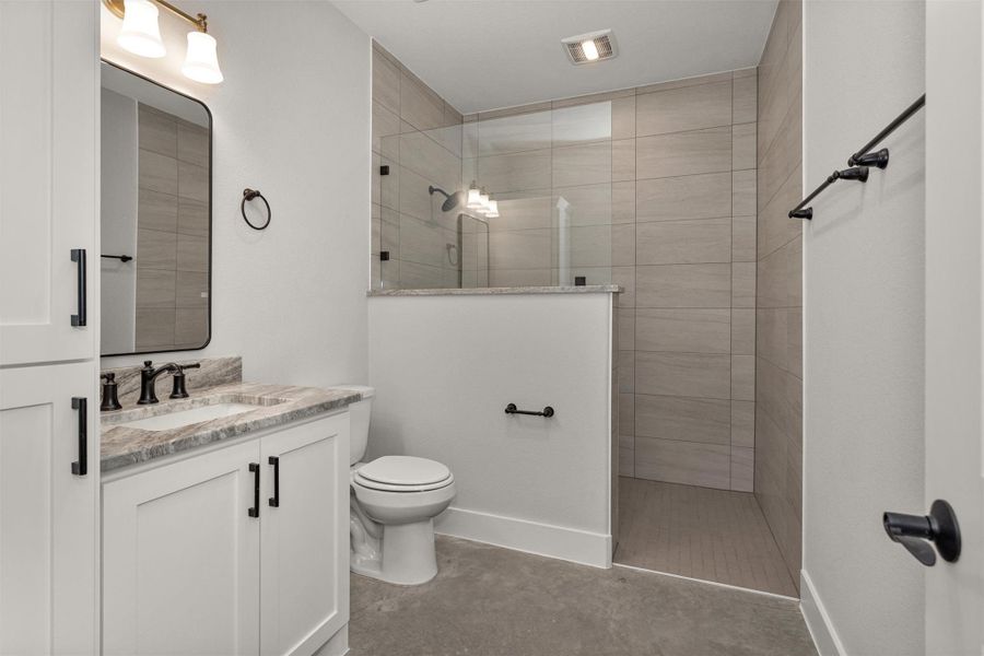 The secondary bathroom features a nicely sized walk-in shower designed for both comfort and functionality. A built-in niche provides convenient storage for shampoo, soap, and bath essentials, keeping the space organized and streamlined.