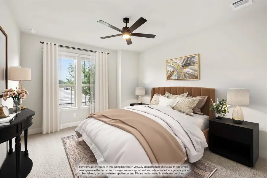 Bedroom with upholstered headboard, ceiling fan, carpet flooring, and large window with white curtains Bedroom with upholstered headboard, ceiling fan, carpet flooring, and large window with white curtains