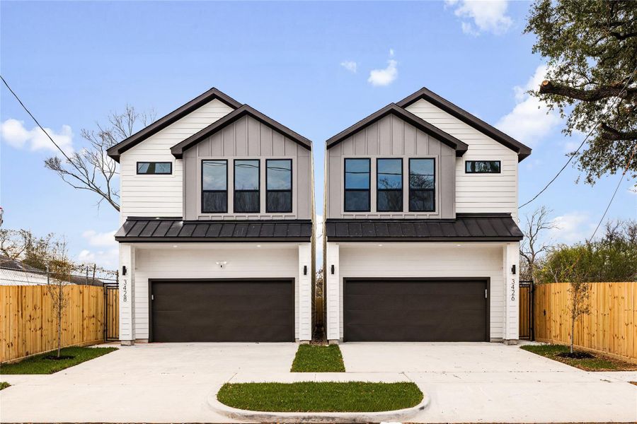 This symmetrical exterior view highlights the home’s modern construction and crisp, updated design. The private fenced sides and wide driveway add both convenience and a sense of separation between homes.
