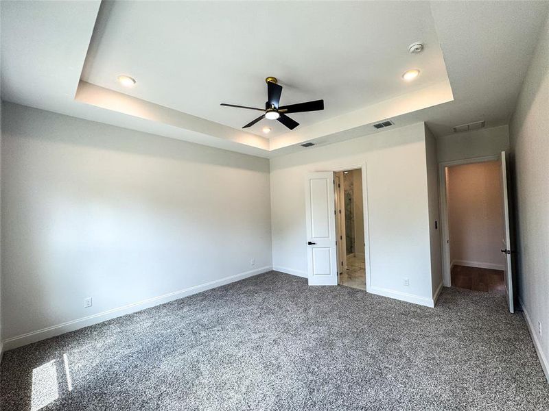 Unfurnished bedroom featuring a raised ceiling, carpet, baseboards, recessed lighting, and ceiling fan Unfurnished bedroom featuring a raised ceiling, carpet, baseboards, recessed lighting, and ceiling fan