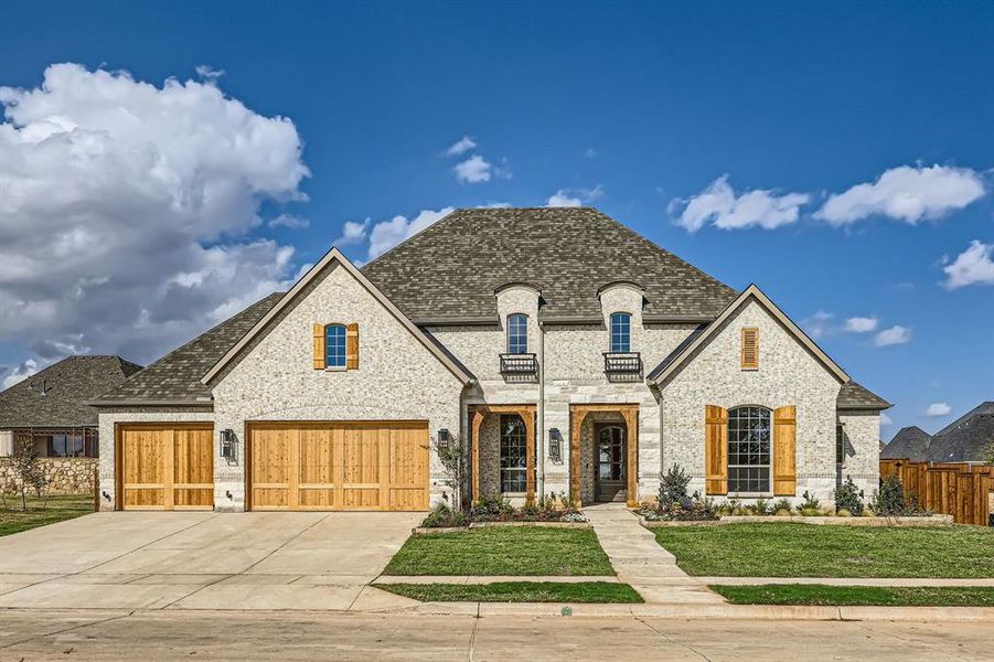 French country home featuring a front yard