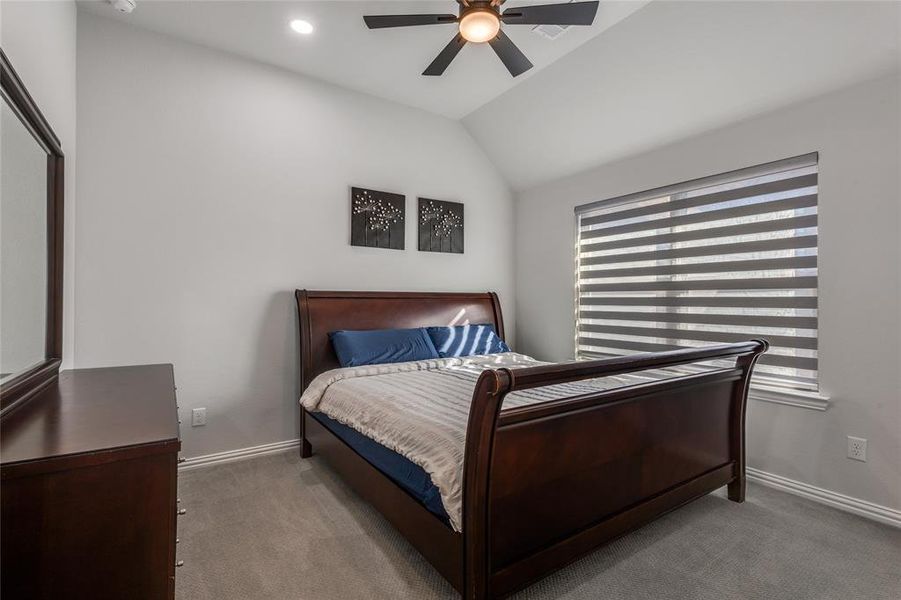 Carpeted bedroom with vaulted ceiling, ceiling fan, and recessed lighting