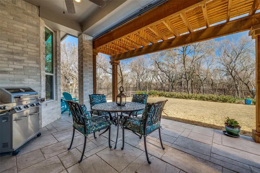 Fenced backyard featuring a pergola, a patio, and an outdoor kitchen / dining area