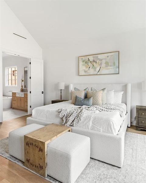 Bedroom with wood finished floors, lofted ceiling, and ensuite bathroom Bedroom with wood finished floors, lofted ceiling, and ensuite bathroom