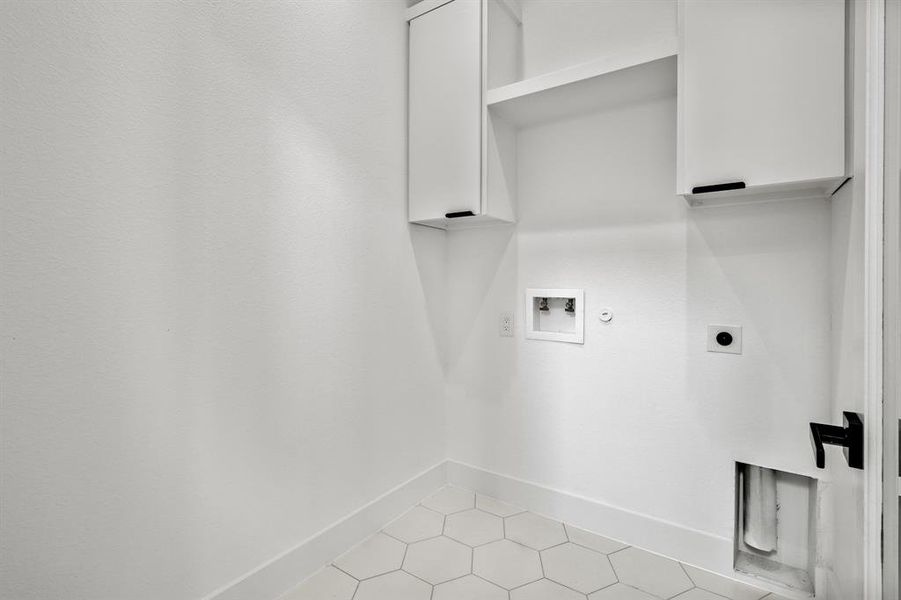 Laundry room with light tile patterned flooring, hookup for a washing machine, electric dryer hookup, and hookup for a gas dryer