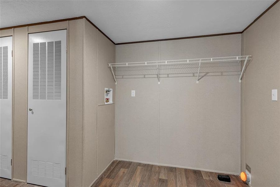 Laundry area featuring wood-type flooring, ornamental molding, and hookup for a washing machine