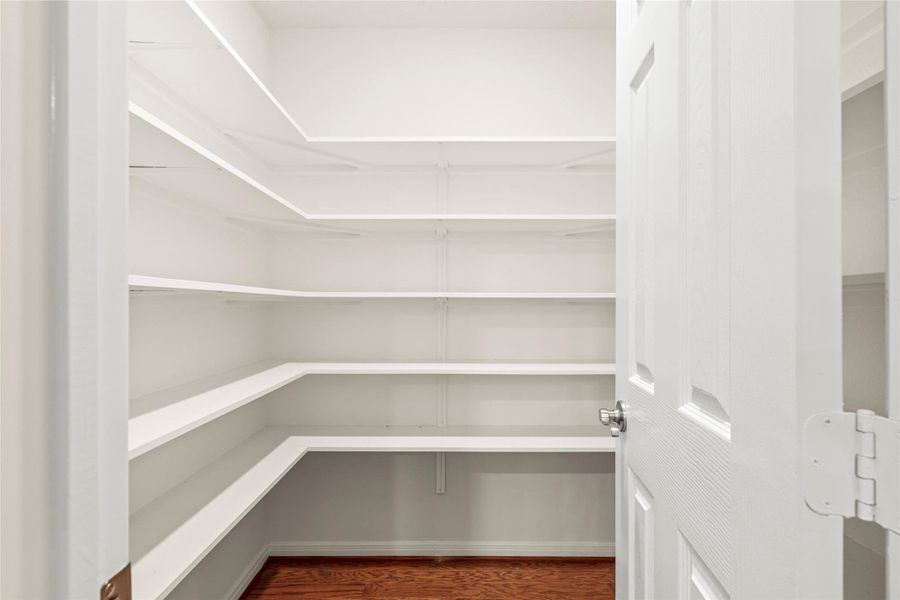 The walk-in pantry boasts floor-to-ceiling custom shelving with generous depth on every level, delivering organized, abundant storage. The walk-in pantry boasts floor-to-ceiling custom shelving with generous depth on every level, delivering organized, abundant storage.