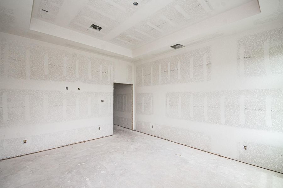 Spacious unfinished primary bedroom with high ceilings, ready for customization and personal touches. Spacious unfinished primary bedroom with high ceilings, ready for customization and personal touches.