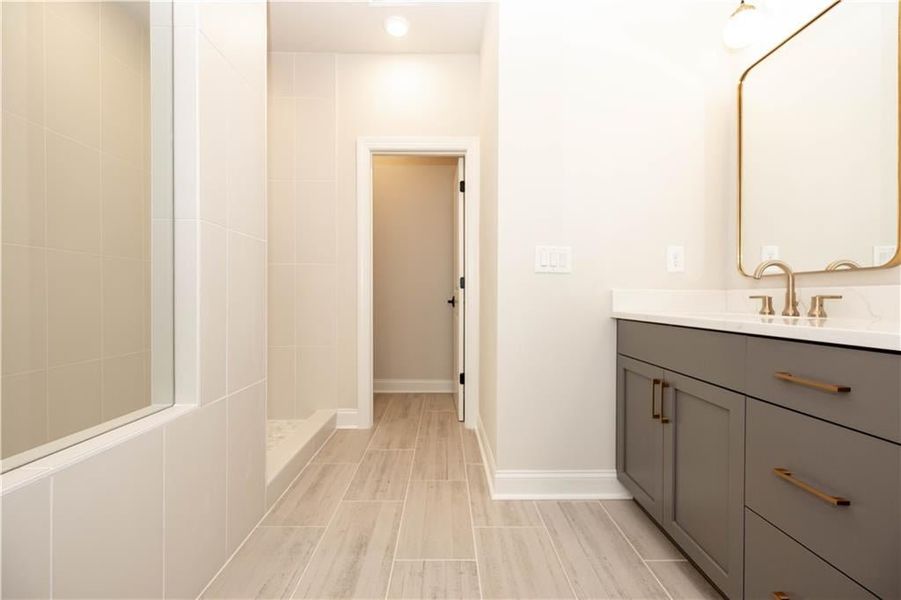 Primary bathroom offers either a large walk in shower that also comes with drying area or a separate tub and shower. Double vanity with quartz tops and framed mirrors *Image is of previously built home* Primary bathroom offers either a large walk in shower that also comes with drying area or a separate tub and shower. Double vanity with quartz tops and framed mirrors *Image is of previously built home*