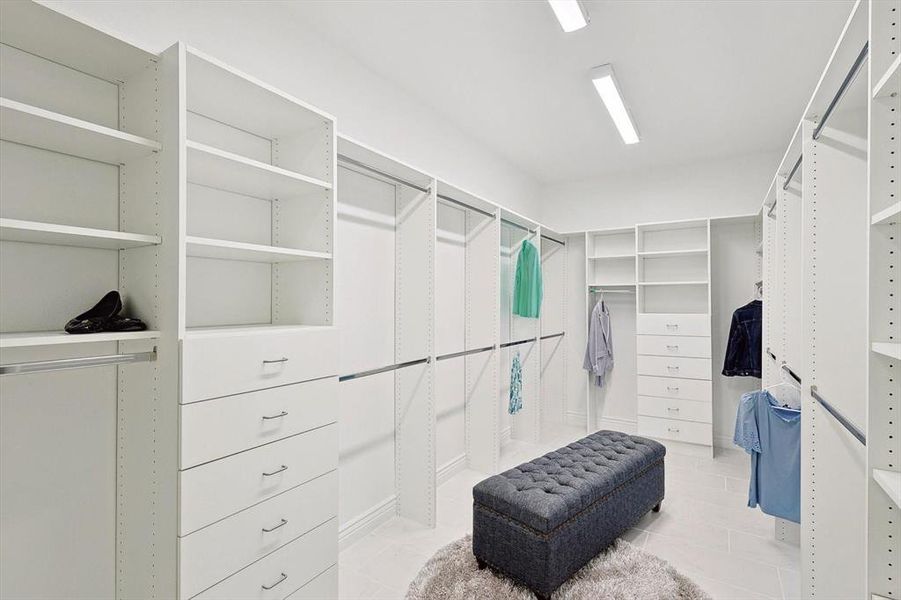 Walk in closet with light tile floors