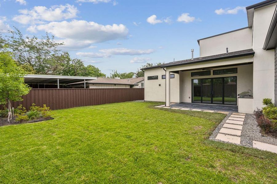Backyard with covered patio and outdoor kitchen. Backyard with covered patio and outdoor kitchen.