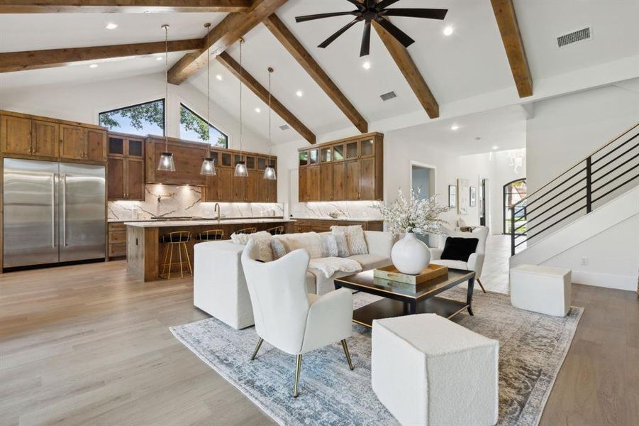 Living room featuring light hardwood / wood-style flooring, ceiling fan, sink, high vaulted ceiling, and beam ceiling