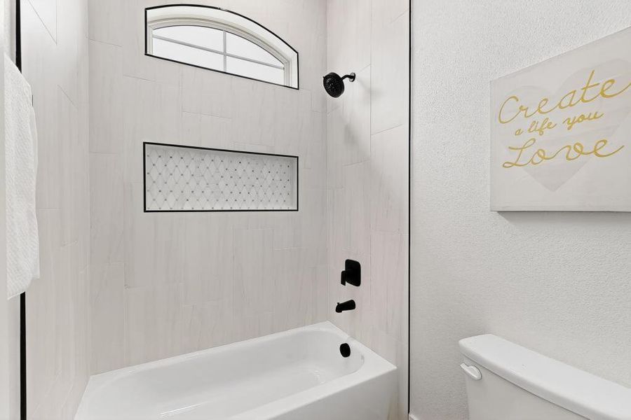 Full bathroom with bathtub / shower combination and a textured wall