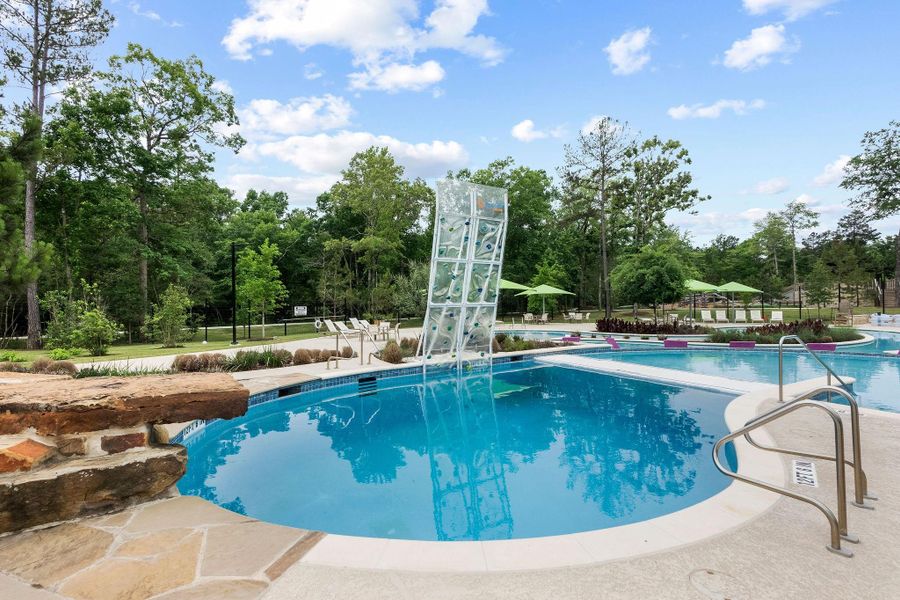 A dedicated dive pool with a rock climbing wall provides a safe and exciting water play space for children, conveniently located adjacent to the main pool and shaded seating.