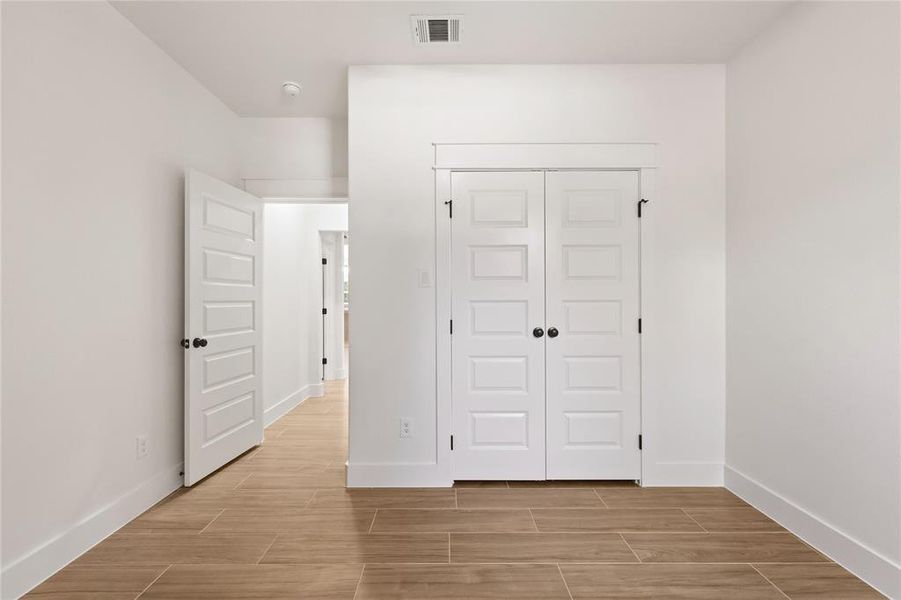 Unfurnished bedroom featuring wood finish floors and a closet