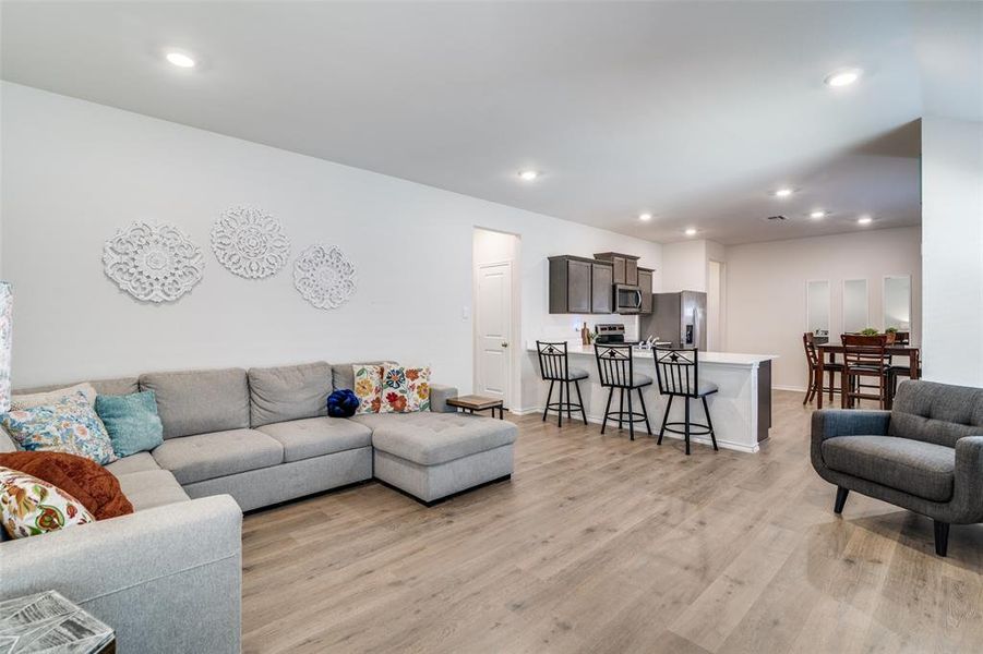 Living area featuring light wood finished floors, baseboards, and recessed lighting