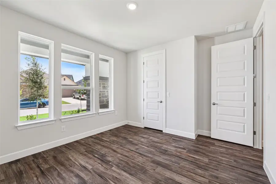 Unfurnished bedroom featuring baseboards and dark wood-style flooring
