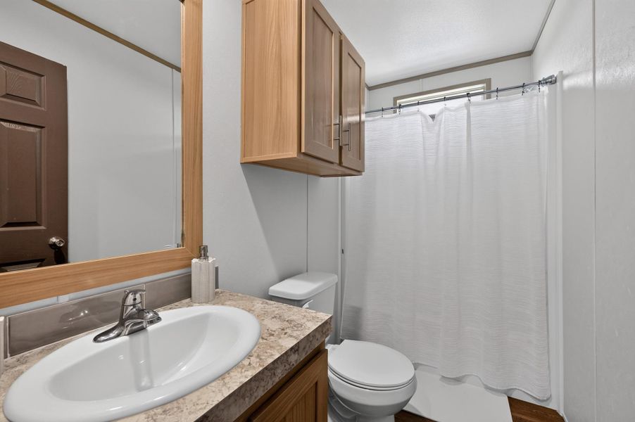 A well-appointed bathroom offers practical vanity storage and a clean, functional layout.