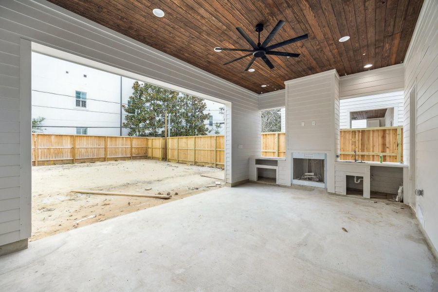 Outdoor Pavillion with a textured concrete patio, Stained Wood Ceiling with Fan, Gas Fireplace, a Stainless Steel Grill, Stainless Steel Sink and more...