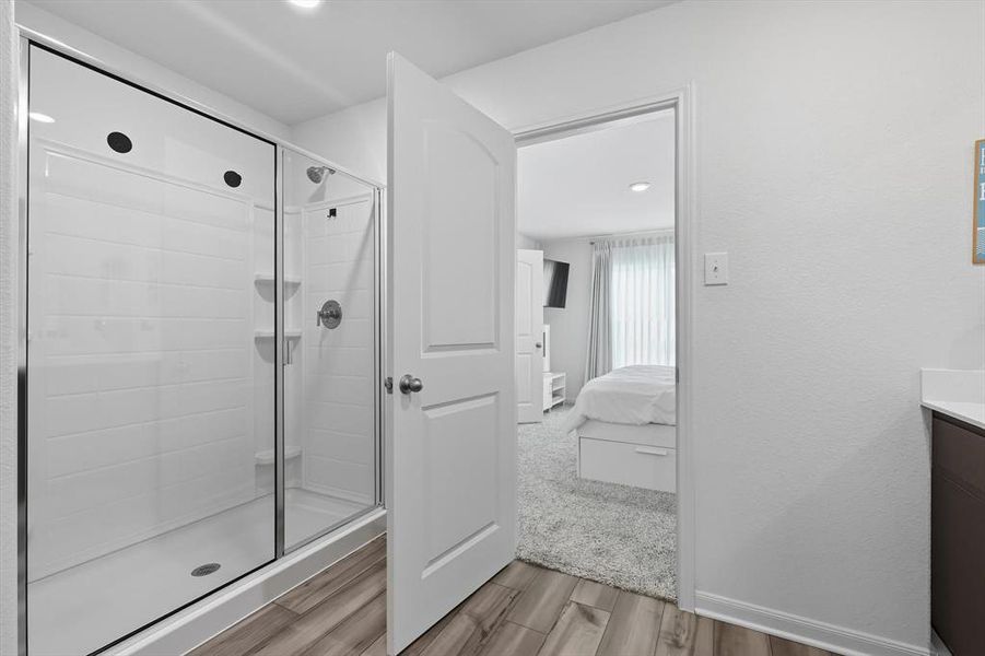Bathroom featuring vanity, a stall shower, ensuite bathroom, light wood-type flooring, and recessed lighting