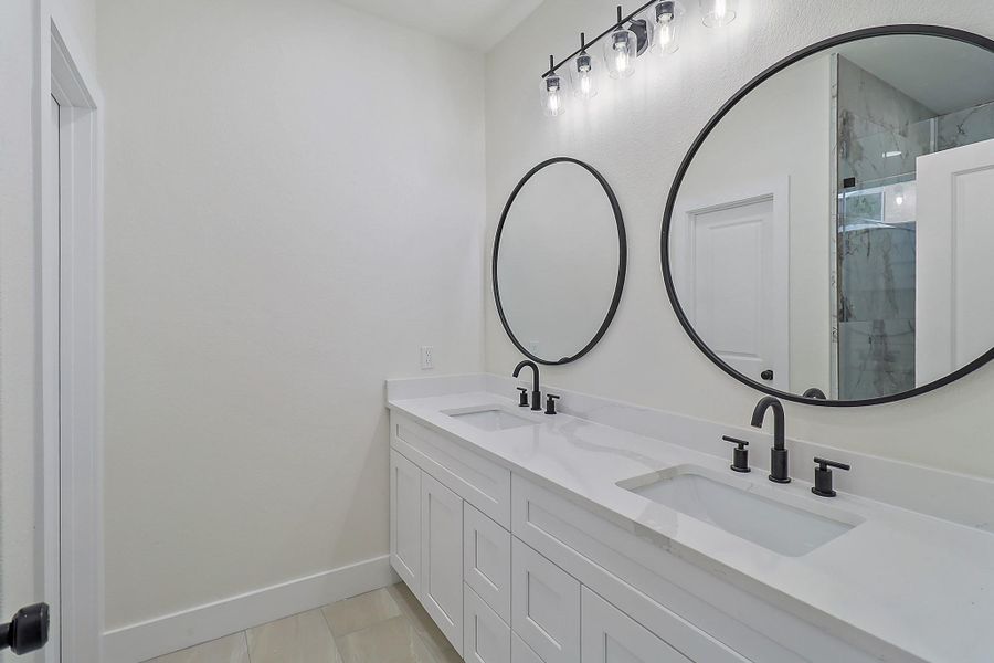 The primary bathroom has a large two sink vanity.