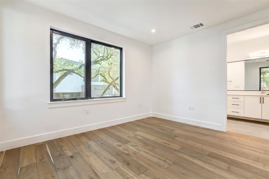 Unfurnished room with baseboards, light wood-type flooring, and recessed lighting