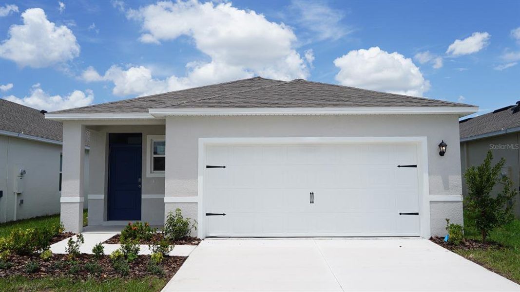 Front exterior of a new home in Magnolia Pointe, Umatilla, FL, highlighting curb appeal (Image 1).