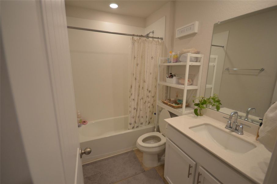 Bathroom with vanity, shower / bath combo with shower curtain, tile patterned flooring, and recessed lighting Bathroom with vanity, shower / bath combo with shower curtain, tile patterned flooring, and recessed lighting