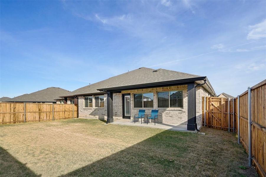 Back of property featuring a yard and a patio