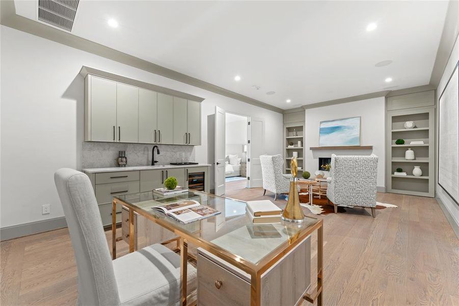 Keeping room off the primary suite features a wet bar with beverage fridge, space for a second office, and fireplace with built ins for a cozy reading nook or tv lounge.