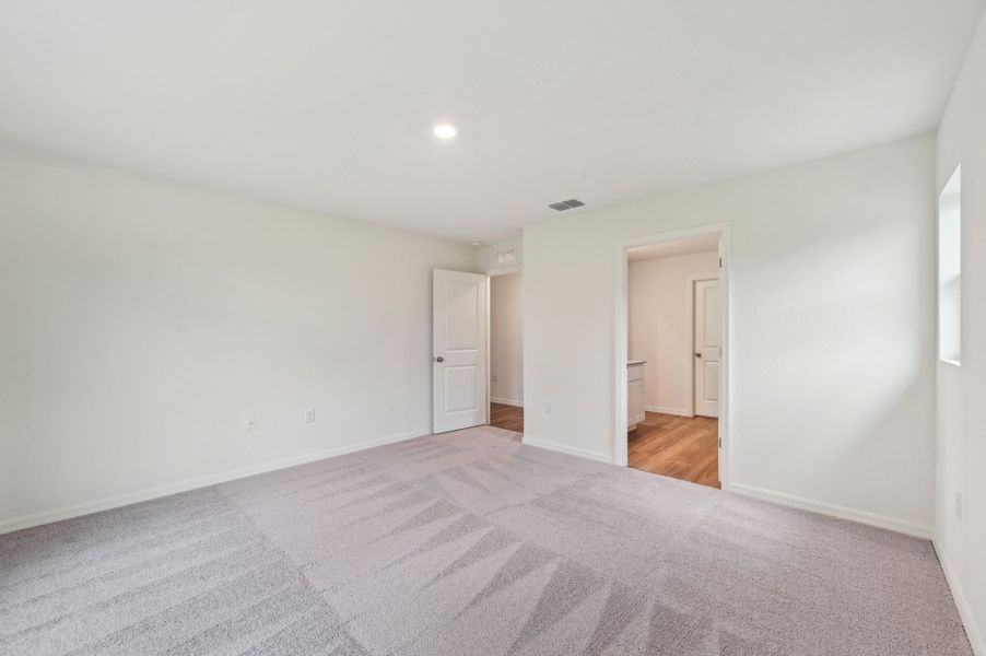 A room with a carpet and a door.