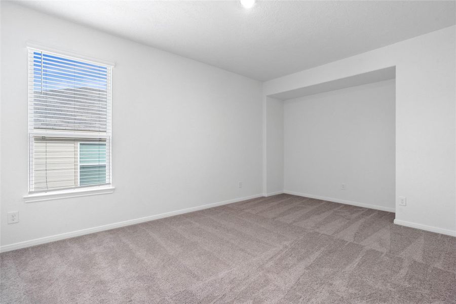 Versatile Den offers cozy carpet flooring, a large window with blinds, and a functional built-in niche, perfect for a media center or display shelves.